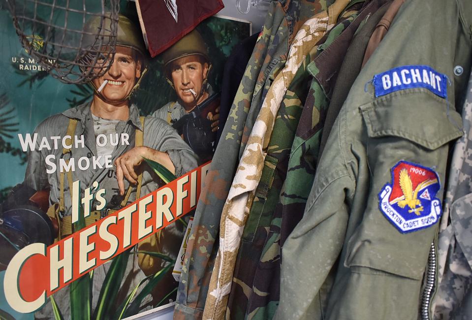 A poster for Chesterfield cigarettes is on display near authentic military jackets at Collectable Firearms & Militaria on Rhode Island in Fall River.