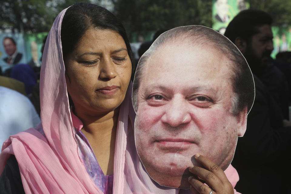 A supporter of Pakistan's ailing former Prime Minister Nawaz Sharif, holds a picture of him at an airport in Lahore, Pakistan, Tuesday, Nov. 19, 2019. Sharif has arrived at the airport to board a plane after a court granted him permission to leave for four weeks abroad for medical treatment. (AP Photo/K.M. Chaudary)