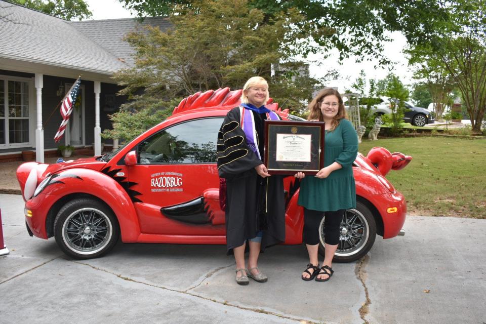 Cheyenne “Star” Lowrey-LaGrone, right, of Fort Smith receives a framed diploma for her Master of Science in Nursing degree from Jan Emory, University of Arkansas associate professor of nursing.