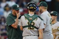 Oakland Athletics pitching coach Scott Emerson, left, talks with Jared Koenig during the second inning of a baseball game against the Boston Red Sox, Tuesday, June 14, 2022, in Boston. (AP Photo/Michael Dwyer)