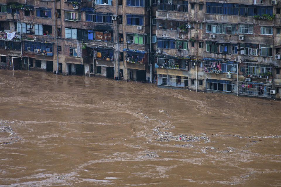 In this photo released by Xinhua News Agency, floodwaters flow past a residential building in Qijiang District of Chongqing Municipality, southwest China on July 1, 2020. A wide swath of southern China braced Sunday, July 5, 2020 for more seasonal rains and flooding. (Chen Xingyu/Xinhua via AP)