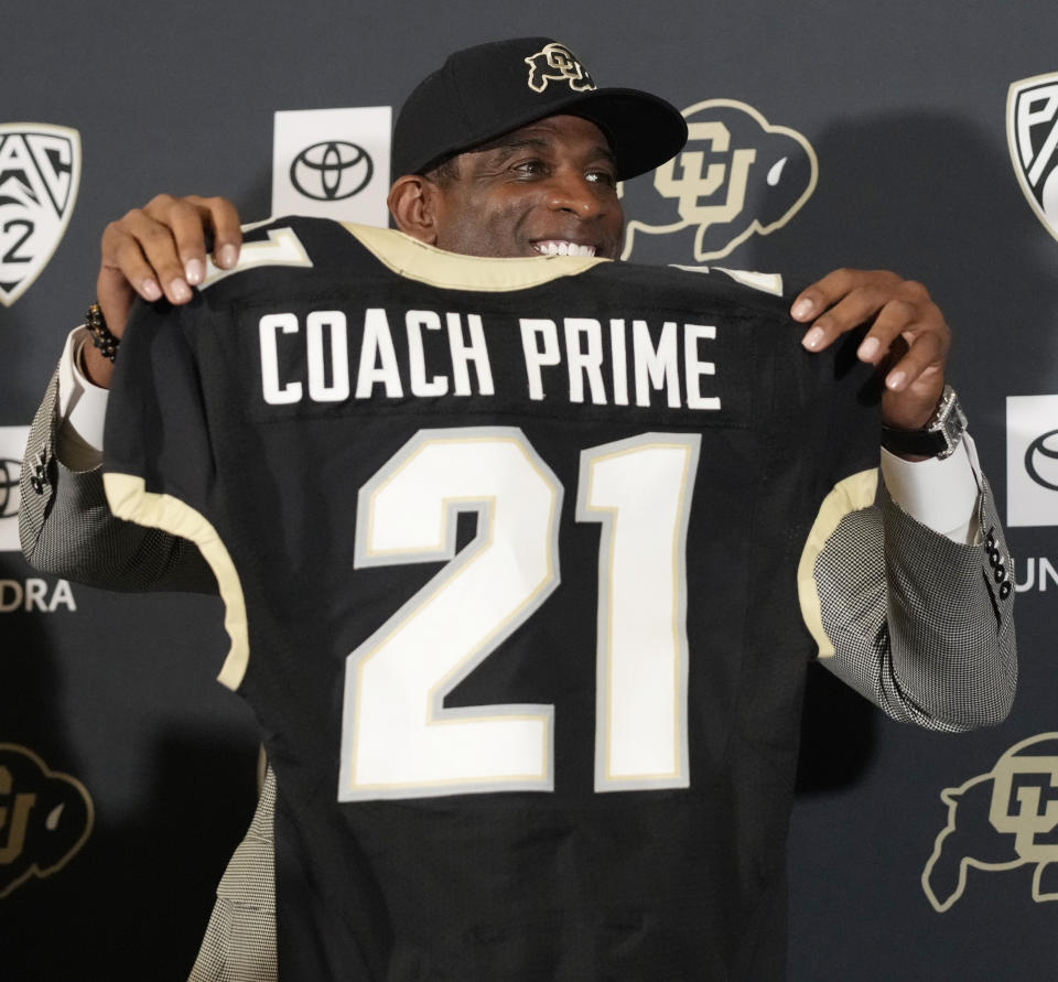 Deion Sanders holds up a jersey before speaking after being introduced as the new head football coach at the University of Colorado during a news conference Sunday, Dec. 4, 2022, in Boulder, Colo. Sanders left Jackson State University after three seasons at the helm of the school's football team. (AP Photo/David Zalubowski)