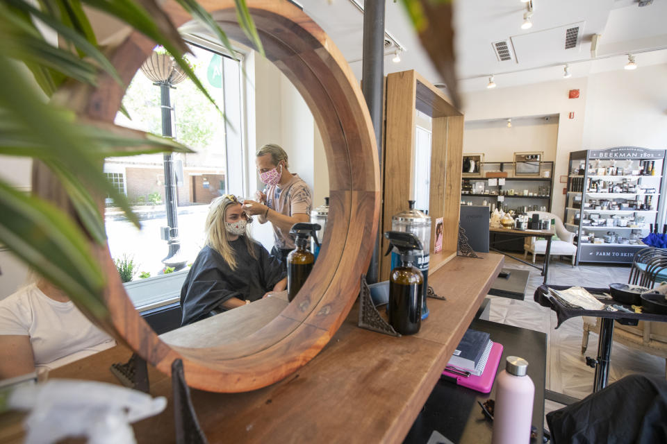 FILE- In this June 1, 2020, file photo hair stylist Zak Moukhtabir works on the hair of Cheyenne Foster at the Georgetown Salon & Spa in Washington. The Trump administration does not have to issue an emergency rule requiring employers to protect workers from the coronavirus, a federal appeals court ruled Thursday, June 11. (AP Photo/Manuel Balce Ceneta, File)