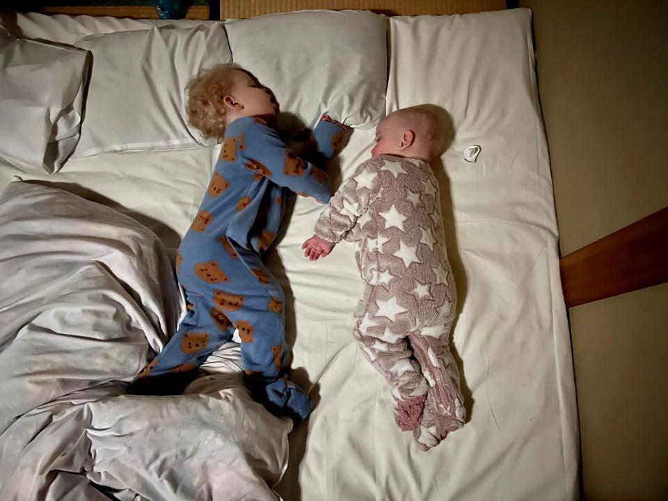 Brother and babies sleeping on a futon in Japan