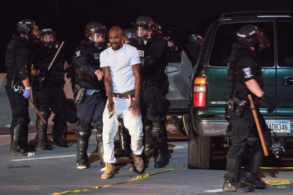 Police officers remove a man from his vehicle.