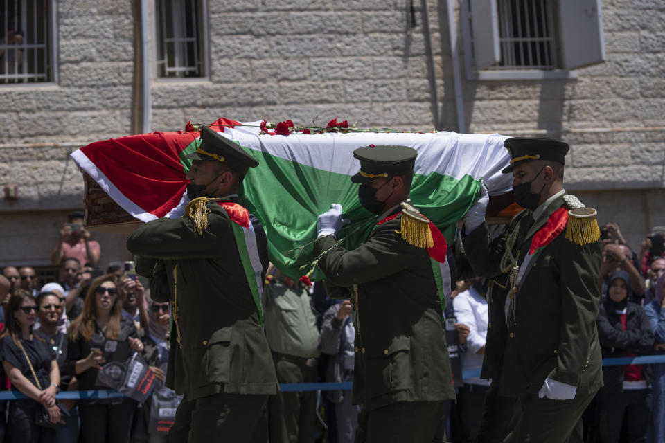 A Palestinian honor guard carry the body of slain Al Jazeera journalist Shireen Abu Akleh, who was shot dead Wednesday during an Israeli military raid in the West Bank city of Jenin, during an official ceremony at the Palestinian Authority headquarters in Ramallah, Thursday, May 12, 2022. Thousands gathered to mourn Abu Akleh in the occupied West Bank city of Ramallah on Thursday, as the head of the Palestinian Authority blamed Israel for her death and rejected Israeli calls for a joint investigation. (AP Photo/Nasser Nasser)