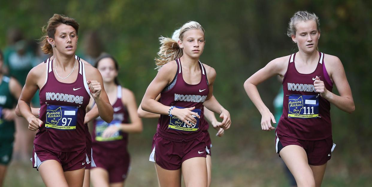 Woodridge's Izzy Best, left, Reese Reaman, center, and Anna Ripple participate in the Metro Athletic Conference cross country meet, Thursday, Oct. 14, 2021, in Norton, Ohio.