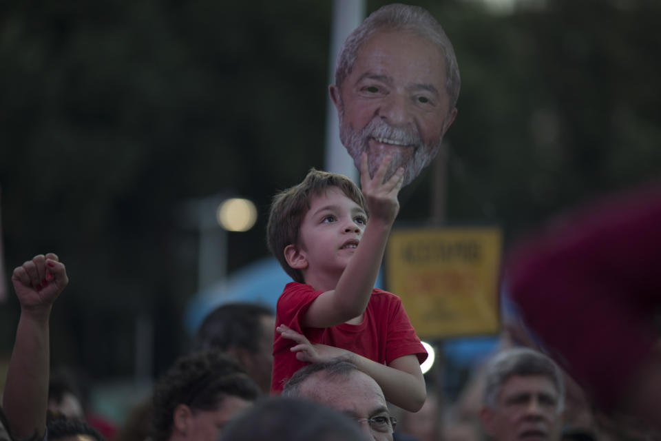 A child holds up a mask depicting the former Brazilian President Luiz Inacio da Silva during the Lula Free festival in Rio de Janeiro, Brazil, Saturday, July 28, 2018. Popular Brazilian musicians and social movements organized a concert to call for the release of da Silva, who has been in prison since April, but continues to lead the preferences on the polls ahead of October's election. (AP Photo/Leo Correa)