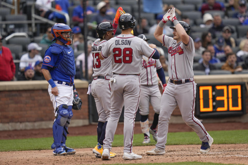 New York Mets catcher Tomas Nido, left, looks on as Atlanta Braves' Sean Murphy, right, celebrates his three run homer with teammates during the seventh inning of the first baseball game of a doubleheader at Citi Field, Monday, May 1, 2023, in New York. (AP Photo/Seth Wenig)