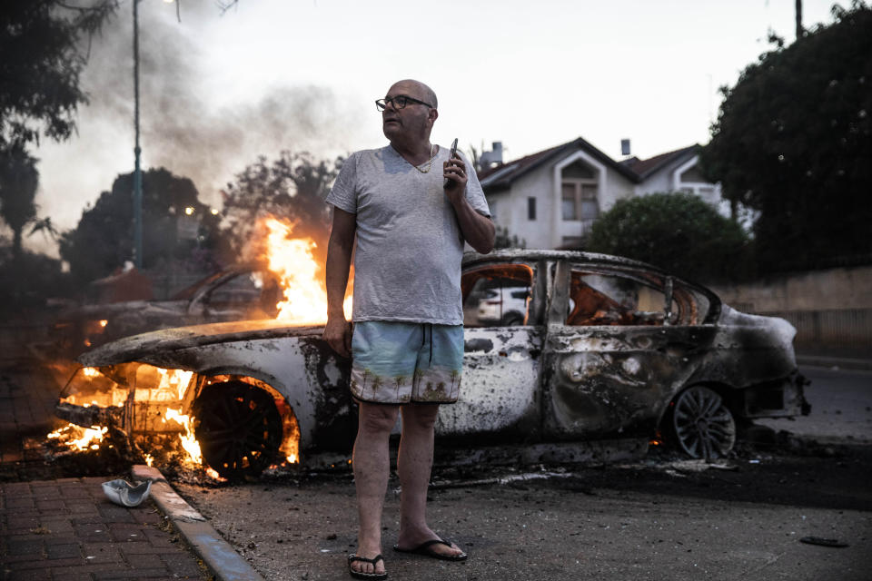 Jacob Simona stands by his burning car during clashes with Israeli Arabs and police in the Israeli mixed city of Lod, Israel Tuesday, May 11,2021. (AP Photo/Heidi Levine)