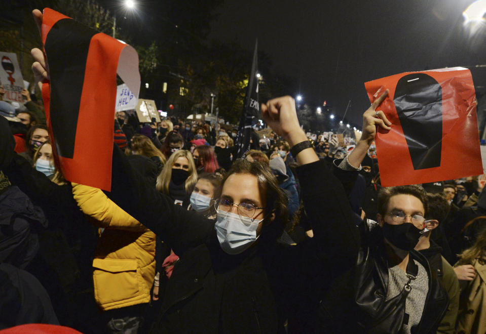 A crowd gathers outside the house of Poland's ruling conservative party leader Jaroslaw Kaczynski in Warsaw, Poland, Friday, Oct. 23, 2020. Protesters vented anger for a second day across Poland over a court ruling that declared abortions of fetuses with congenital defects unconstitutional. The hundreds of protesters who gathered in many cities defied a COVID-19-related ban on gatherings that was imposed nationwide on Friday. (AP Photo/Czarek Sokolowski)