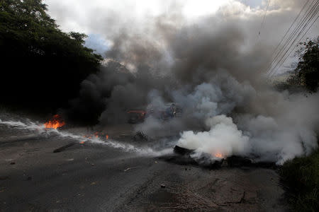 A police water cannon extinguishes burning tires set alight by opposition supporters during a protest over a contested presidential election with allegations of electoral fraud in Tegucigalpa, Honduras, December 22, 2017. REUTERS/Jorge Cabrera