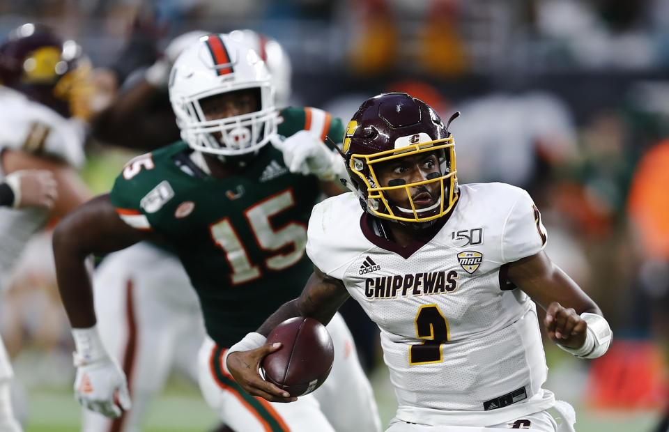 Central Michigan quarterback David Moore (2) runs with the ball against Miami defensive lineman Gregory Rousseau (15) during the second half of an NCAA college football game, Saturday, Sept. 21, 2019, in Miami Gardens, Fla. (AP Photo/Brynn Anderson)