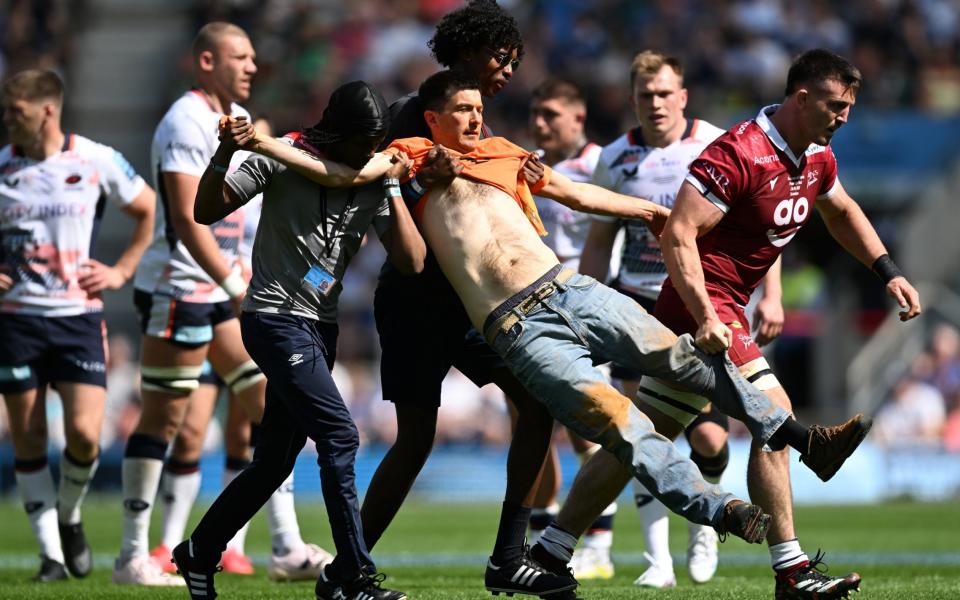 A 'Just Stop Oil' protestor invades the pitch and is apprehended by stewards during the Gallagher Premiership Final between Saracens and Sale Sharks at Twickenham - Players and fans turn on Just Stop Oil protesters as Premiership Rugby final interrupted - Getty Images/Mike Hewitt