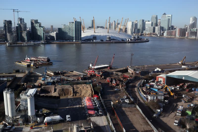 FILE PHOTO: Construction work near the River Thames on the Greenwich Peninsula is seen next to the O2 and Canary Wharf financial district in London