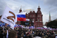 FILE - Demonstrators hold Russian state flags and flags with with the letter Z, which has become a symbol of the Russian military, and a hashtag reading "We don't abandon our own" during the action "We do not abandon our own" to support the referendum, on Manezhnaya Square near the Kremlin and Red Square with the Historical Museum in the background in Moscow, Russia, Friday, Sept. 23, 2022. The All-Russia People's Front organized a rally in support of the referendums in the four Moscow-held regions of Ukraine to become part of Russia. (AP Photo/Alexander Zemlianichenko, File)