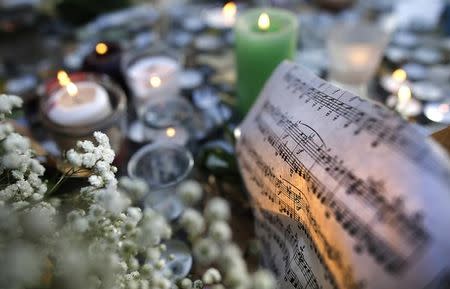 Sheet music is seen amongst candles near the site of the attack at the Bataclan concert hall in Paris, November 15, 2015. REUTERS/Christian Hartmann