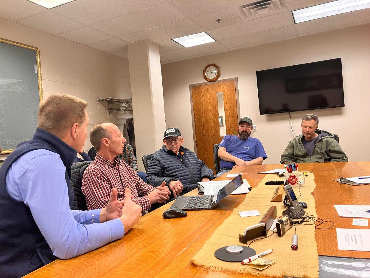 Greg Courter (left) and Chris Snider, from National Grid Renewables, talk with Charles Stockmaster, Tom Stockmaster and other residents about the Sycamore Creek solar project. Construction is scheduled to begin on it in June.