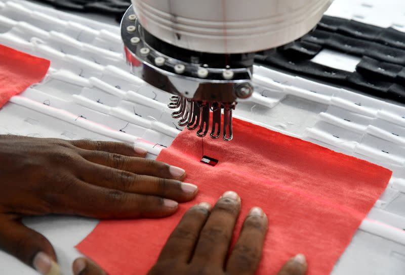 An automated embroidery machine stitches the logo of Tommy Hilfiger brand on a piece of a garment at a textile factory of Texport Industries in Hindupur