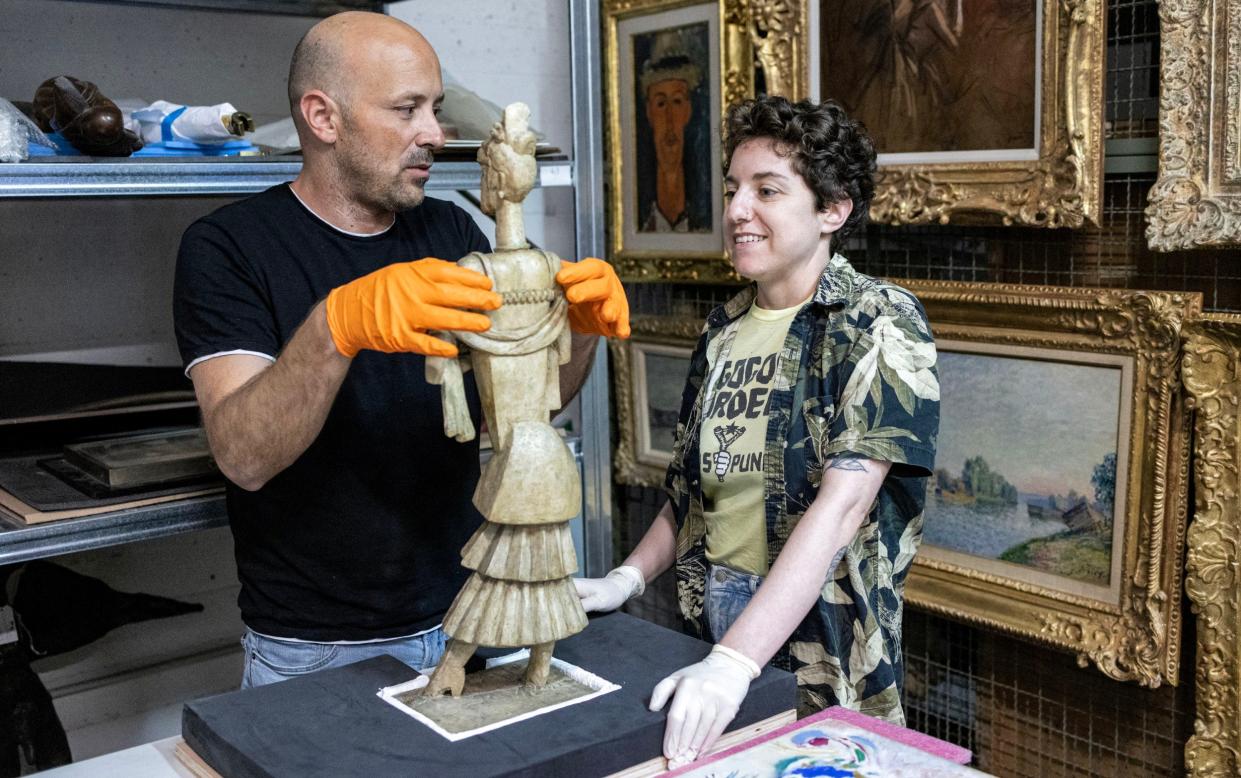 Staff prepare a sculpture by Jack Lipschitz for storage in a safe room