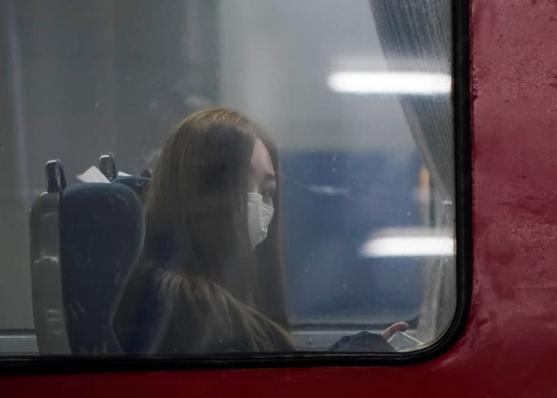 A passenger wearing a mask to prevent contacting the coronavirus sits inside a train at Seoul Railway Station in Seoul