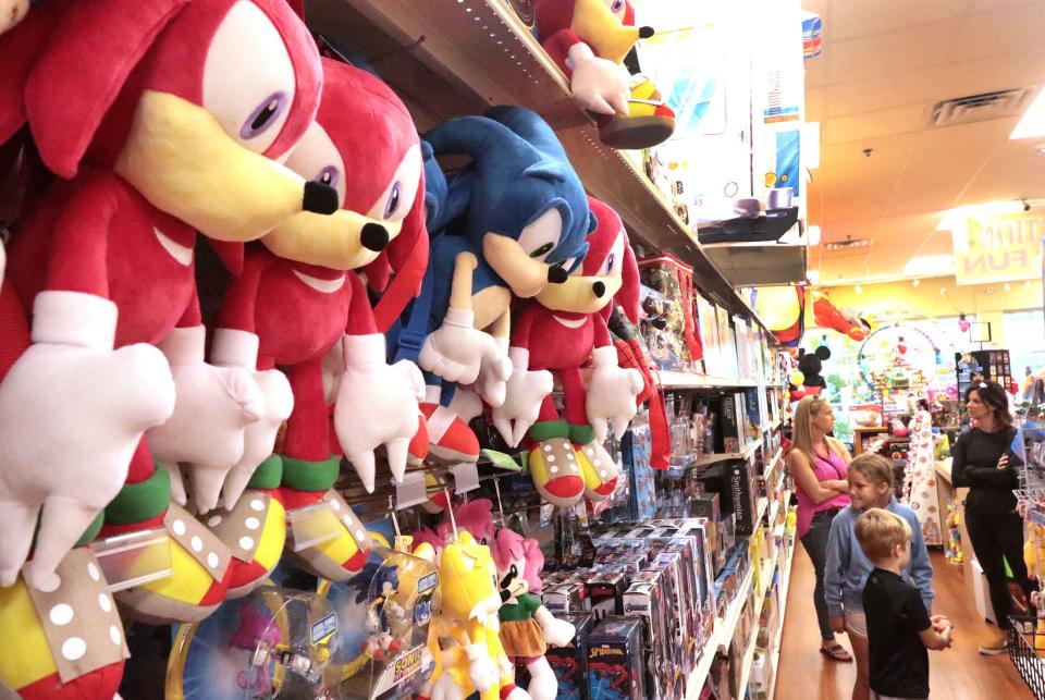 Shoppers wiith youngsters in tow browse the aisles at Destination Fun toy store on Monday at Tanger Outlets mall in Daytona Beach. Although many shoppers started their buying early this year, retailers still expect crowds on Black Friday.