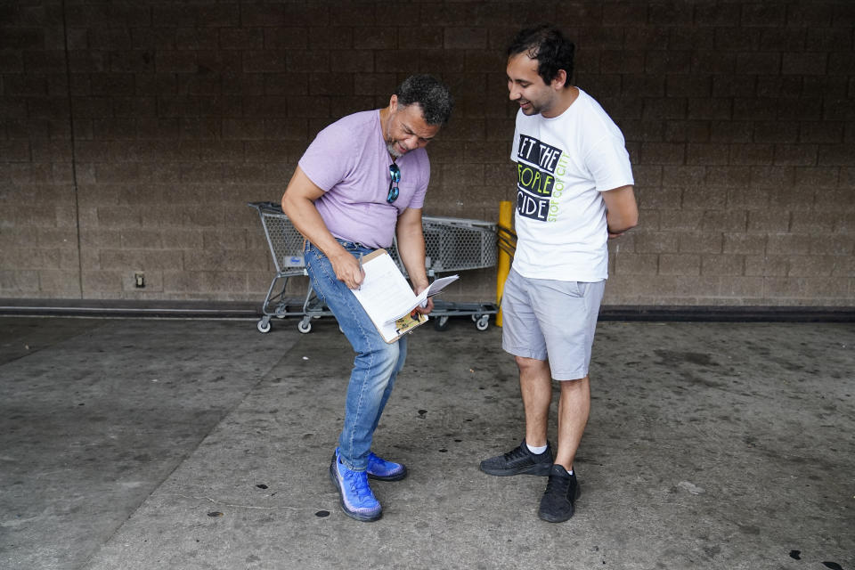 Gabriel Sanchez, right, talks with Atlanta resident, Bobby Thornton, left, Thursday, July 20, 2023, in Atlanta. Activists with the Stop Cop City Vote Coalition are trying to get the signatures of more than 70,000 Atlanta residents by Aug. 14 to force a referendum allowing voters to decide the fate of a proposed police and firefighter training center. (AP Photo/Brynn Anderson)