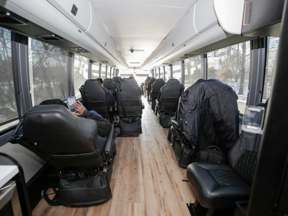 The back of the bus looking towards the front and rows of seats.