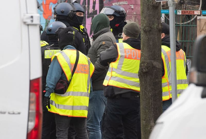 Police officers lead a man away during an operation connected with the manhunt for the two suspected robbers Ernst-Volker Staub and Burkhard Garweg, who are still on the run. Paul Zinken/dpa