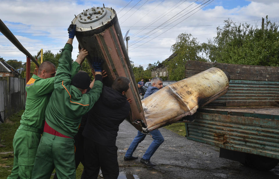 Communal workers load remains of a missile into a truck after an overnight Russian attack in Kramatorsk, Ukraine, Tuesday, Oct. 4, 2022. (AP Photo/Andriy Andriyenko)