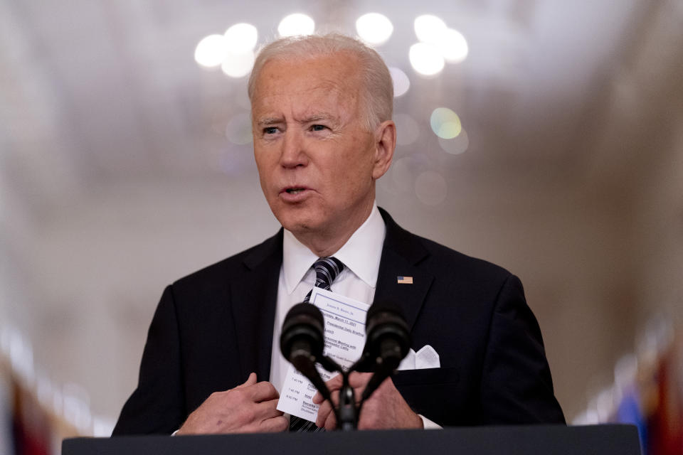 FILE - In this March 11, 2021, file photo President Joe Biden holds up a card with his daily schedule and the daily deaths from COVID-19 as he speaks about the COVID-19 pandemic during a prime-time address from the East Room of the White House in Washington. (AP Photo/Andrew Harnik, File)