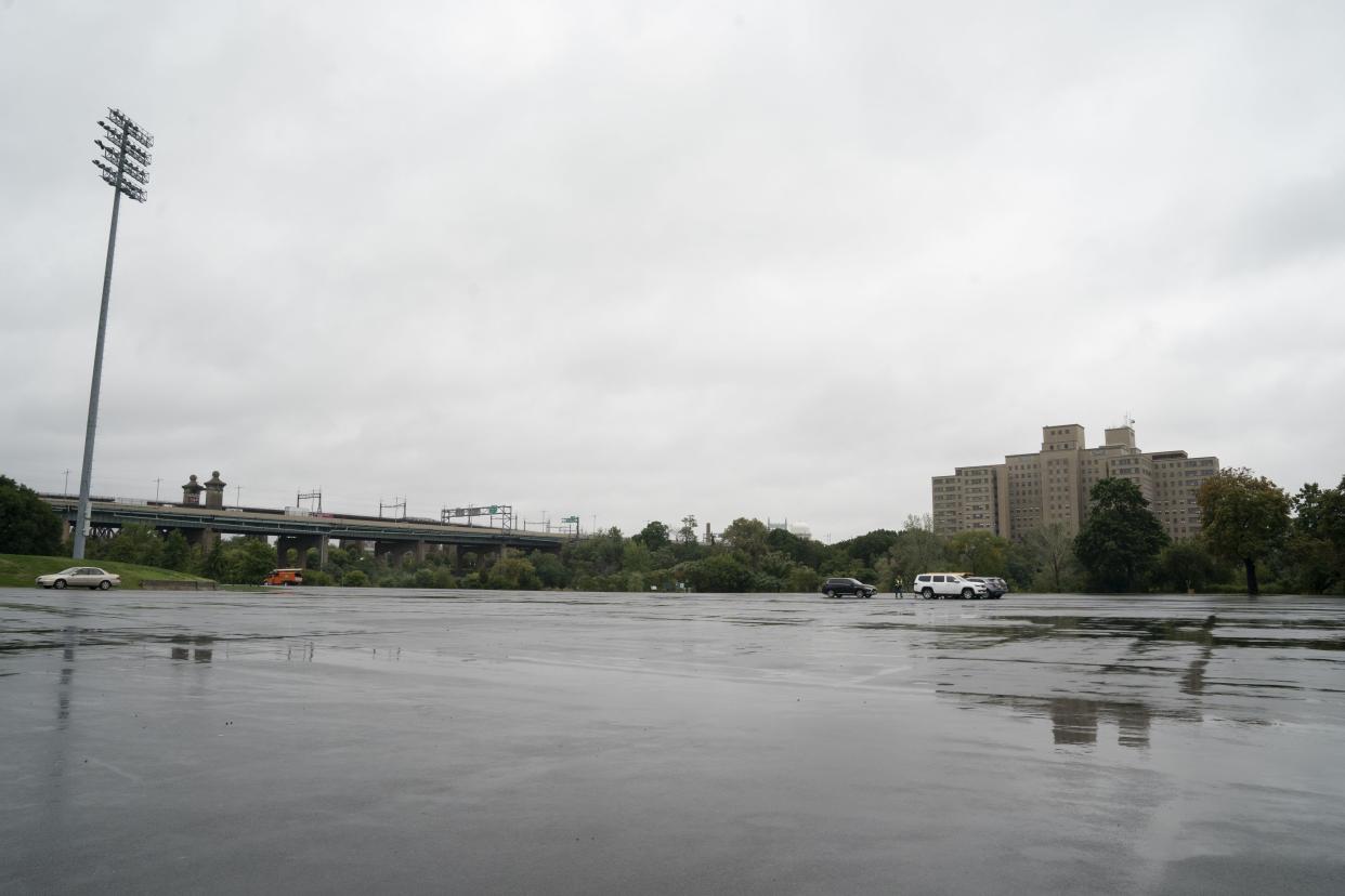 An NYC Emergency Management employee and others prepare to survey the parking lot at Iachn Statium at Randalls Island Tuesday, Oct. 4, 2022 in the Bronx. 