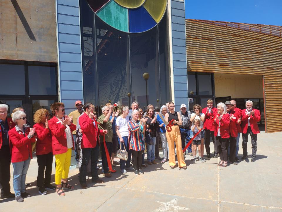 Amarillo Art Institute Executive Director Rachel Flores, members of the Amarillo Chamber of Commerce and artists celebrate the soft opening for Arts in the Sunset Center, after two years of renovations, during Friday afternoon's ribbon cutting.