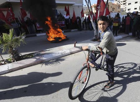 A Palestinian boy looks on during a protest against the United Nations decision to suspend payments for Palestinians, whose houses were damaged during a 50-day war last summer, outside a U.N. office in Khan Younis in the southern Gaza Strip January 29, 2015. REUTERS/Ibraheem Abu Mustafa