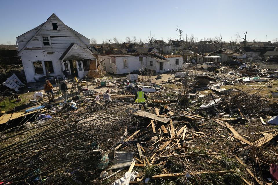 FILE - Voluteers help Martha Thomas, second from left, salvage possessions from her destroyed home, in the aftermath of tornadoes that tore through the region, in Mayfield, Ky., Dec. 13, 2021. (AP Photo/Gerald Herbert, File)