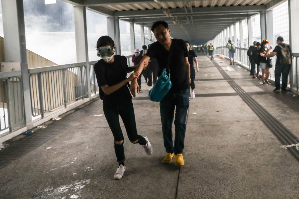 TOPSHOT - Protesters leave the area after police fired tear gas during a rally against a controversial extradition law proposal outside the government headquarters in Hong Kong on June 12, 2019. - Violent clashes broke out in Hong Kong on June 12 as police tried to stop protesters storming the city's parliament, while tens of thousands of people blocked key arteries in a show of strength against government plans to allow extraditions to China. (Photo by DALE DE LA REY / AFP)        (Photo credit should read DALE DE LA REY/AFP/Getty Images)