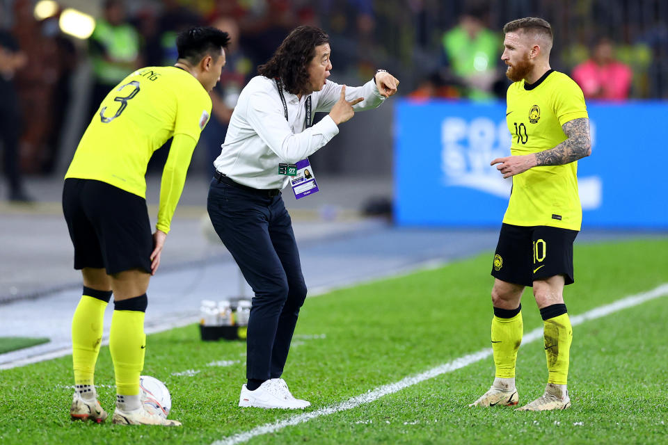 Malaysia national football head coach Kim Pan-gon (centre) gives instructions to Quentin Cheng (left) and Lee Tuck in their AFF Mitsubishi Electric Cup semi-final match against Thailand at the Bukit Jalil National Stadium. 