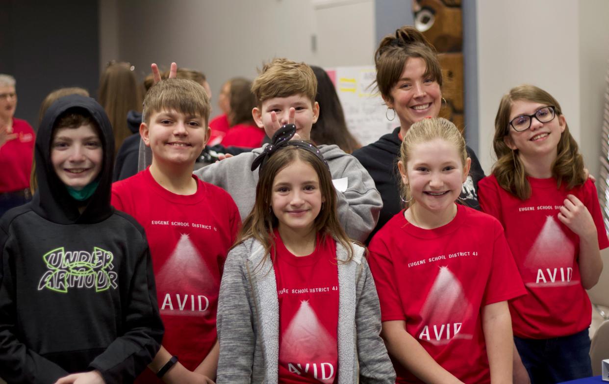 Marie Rose, third grade teacher at Awbrey Park Elementary, poses with current and former students during an AVID Spotlight event for Eugene School District 4J on Thursday, March 8, 2024.