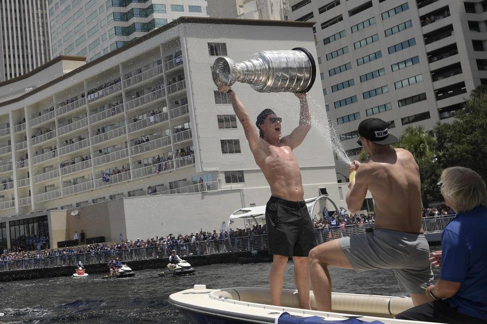 Tampa Bay Lightning left wing Ondrej Palat is sprayed by defenseman Jan Rutta, while hoisting the Stanley Cup during the NHL hockey Stanley Cup champions' Boat Parade, Monday, July 12, 2021, in Tampa, Fla. (AP Photo/Phelan M. Ebenhack)