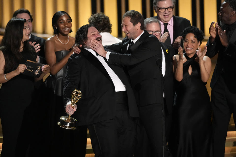 Matty Matheson, centro, y Ebon Moss-Bachrach se besan después de que "The Bear" ganara el premio a mejor comedia en la 75a edición de los Premios Emmy el lunes 15 de enero de 2024 en el Teatro Peacock de Los Ángeles. (Foto AP/Chris Pizzello)