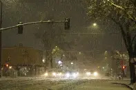 In this photo provided by Hung T. Vu, snow falls on North Market Street in Redding, Calif., early Friday, Feb. 24, 2023. Heavy rain and snow are pounding California and other parts of the West in the latest winter storm to hit the United States. (Hung T. Vu via AP)