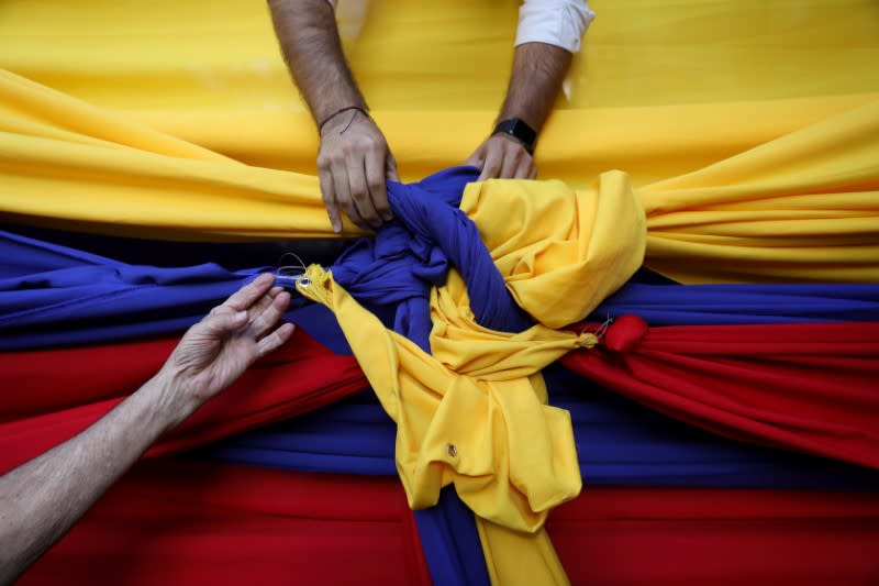 People untie cloth tarps with colors of Venezuelan flag after a citizen assembly with Juan Guaido, president of Venezuela's National Assembly in Caracas