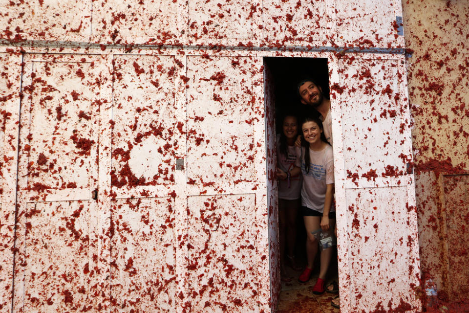 People are photographed inside a house during the annual tomato fight fiesta called “Tomatina” in the village of Bunol near Valencia, Spain, Wednesday, Aug. 30, 2023. Thousands gather in this eastern Spanish town for the annual street tomato battle that leaves the streets and participants drenched in red pulp from 120,000 kilos of tomatoes. (AP Photo/Alberto Saiz)