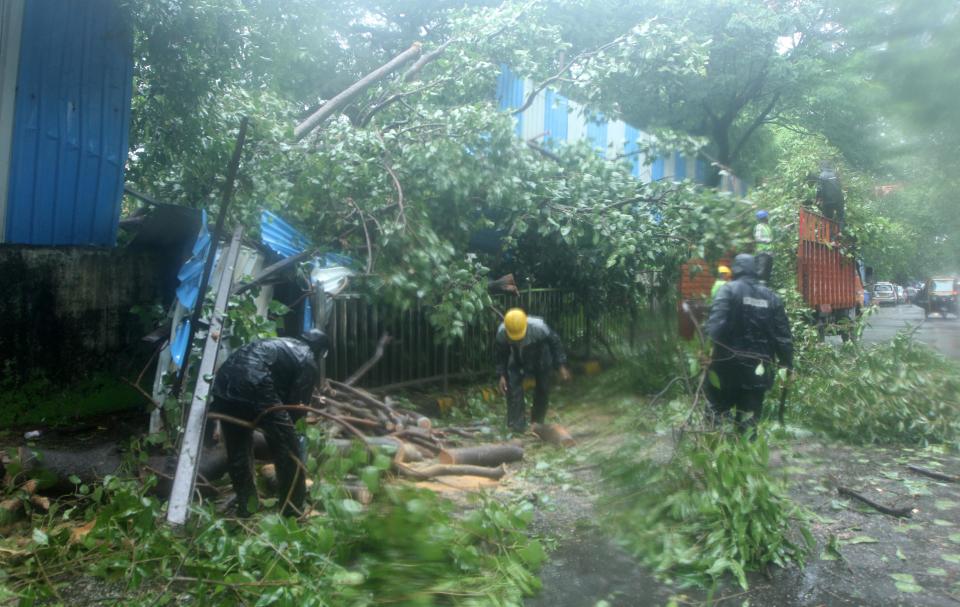 Rescue workers clean up debris after heavy rains lash Mumbai. (Photo by Arun Patil)