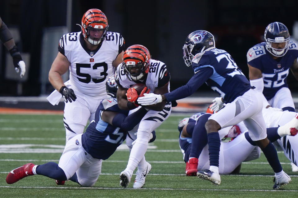 Cincinnati Bengals' Giovani Bernard (25) is tackled by Tennessee Titans' Jayon Brown (55) and Chris Jackson (35) during the first half of an NFL football game, Sunday, Nov. 1, 2020, in Cincinnati. (AP Photo/Bryan Woolston)