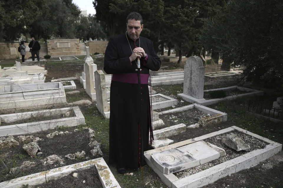 Hosam Naoum, a Palestinian Anglican bishop, pauses where vandals desecrated more than 30 graves at a historic Protestant Cemetery on Jerusalem's Mount Zion in Jerusalem, Wednesday, Jan. 4, 2023. Israel's foreign ministry called the attack an 