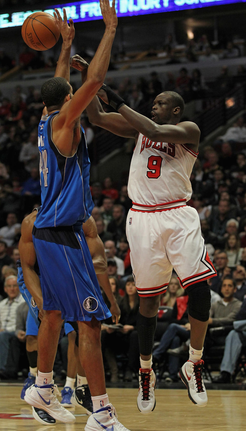 CHICAGO, IL - APRIL 21: Loul Deng #9 of the Chicago Bulls passes over Brandon Wright #34 of the Dallas Mavericks at the United Center on April 21, 2012 in Chicago, Illinois. The Bulls defeated the Mavericks 93-83. NOTE TO USER: User expressly acknowledges and agress that, by downloading and/or using this photograph, User is consenting to the terms and conditions of the Getty Images License Agreement. (Photo by Jonathan Daniel/Getty Images)