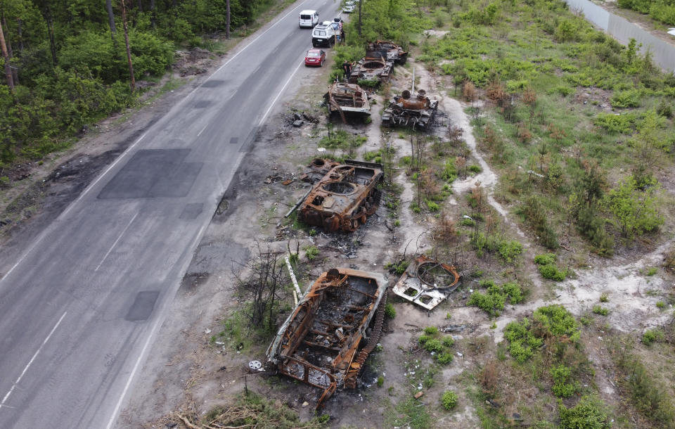 An aerial view of Ukrainian people inspecting and taking photos of destroyed tanks at the area between the villages of Dmitrivka, Zabuchia, which is 27 kilometers from the center of Kyiv, Ukraine on May 27, 2022. (Dogukan Keskinkilic/Anadolu Agency via Getty Images)