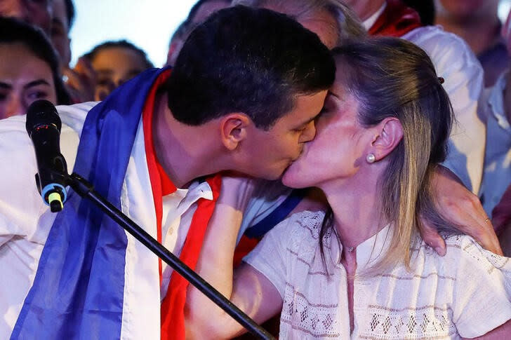 Foto del domingo del candidato de Partido Colorado Santiago Peña celebrando tras ganar la elección presidencial de Paraguay en Asunción con un beso a su esposa Leticia Ocampos