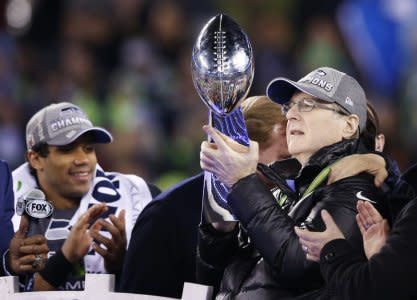 Seattle Seahawks owner Paul Allen holds the Vince Lombardi Trophy next to quarterback Russell Wilson after they defeted the Denver Broncos in the NFL Super Bowl XLVIII football game in East Rutherford, New Jersey, February 2, 2014. REUTERS/Shannon Stapleton (UNITED STATES  - Tags: SPORT FOOTBALL)